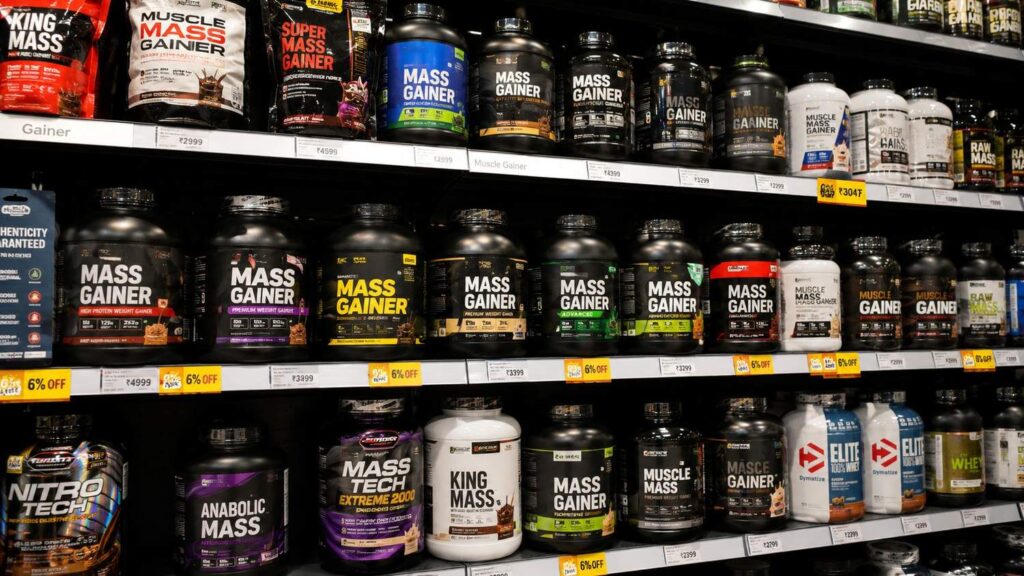 Store bought mass gainer supplement tubs displayed on shelf.
